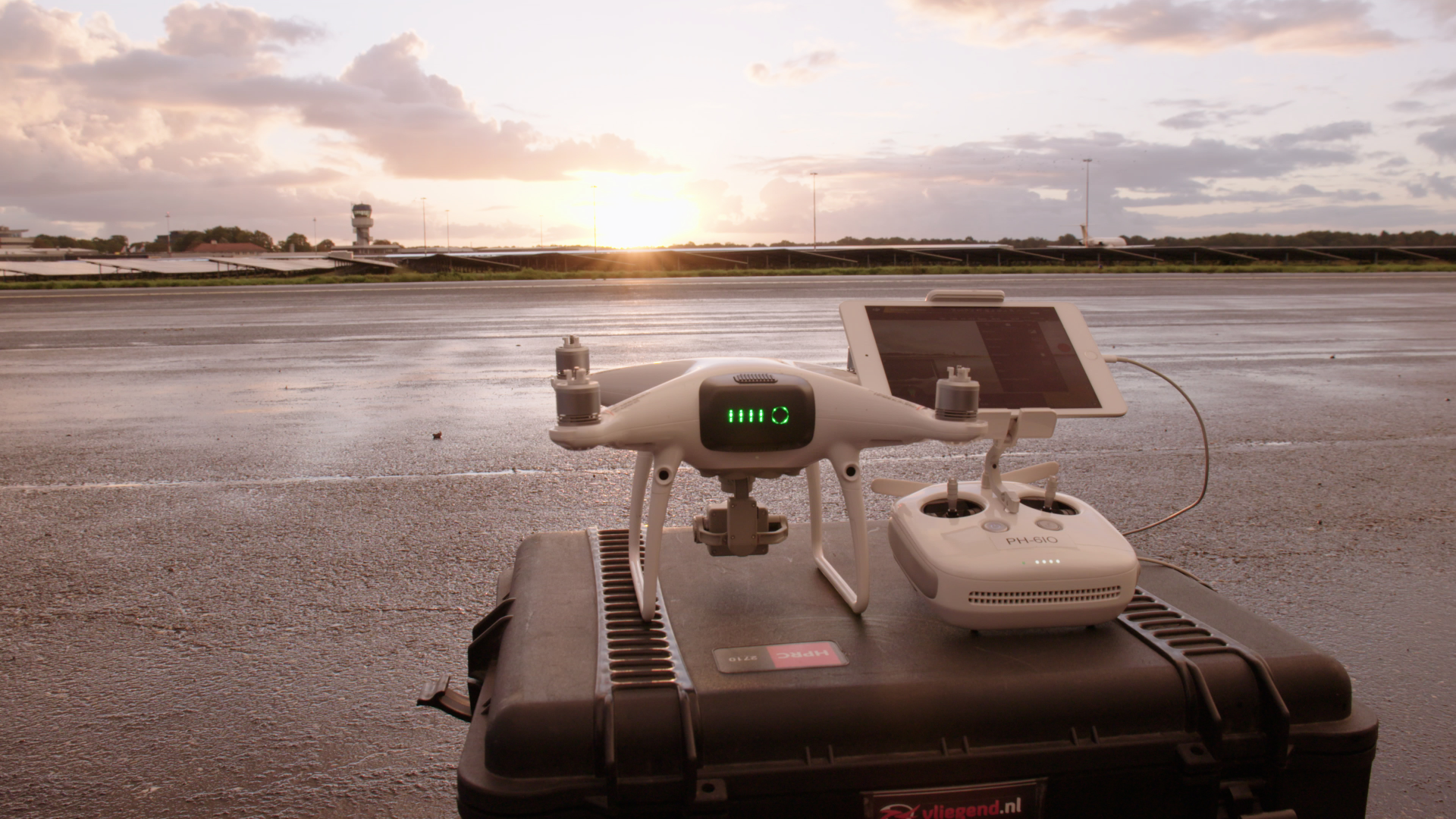 Een drone naast een meetinstrument op een vliegveld.