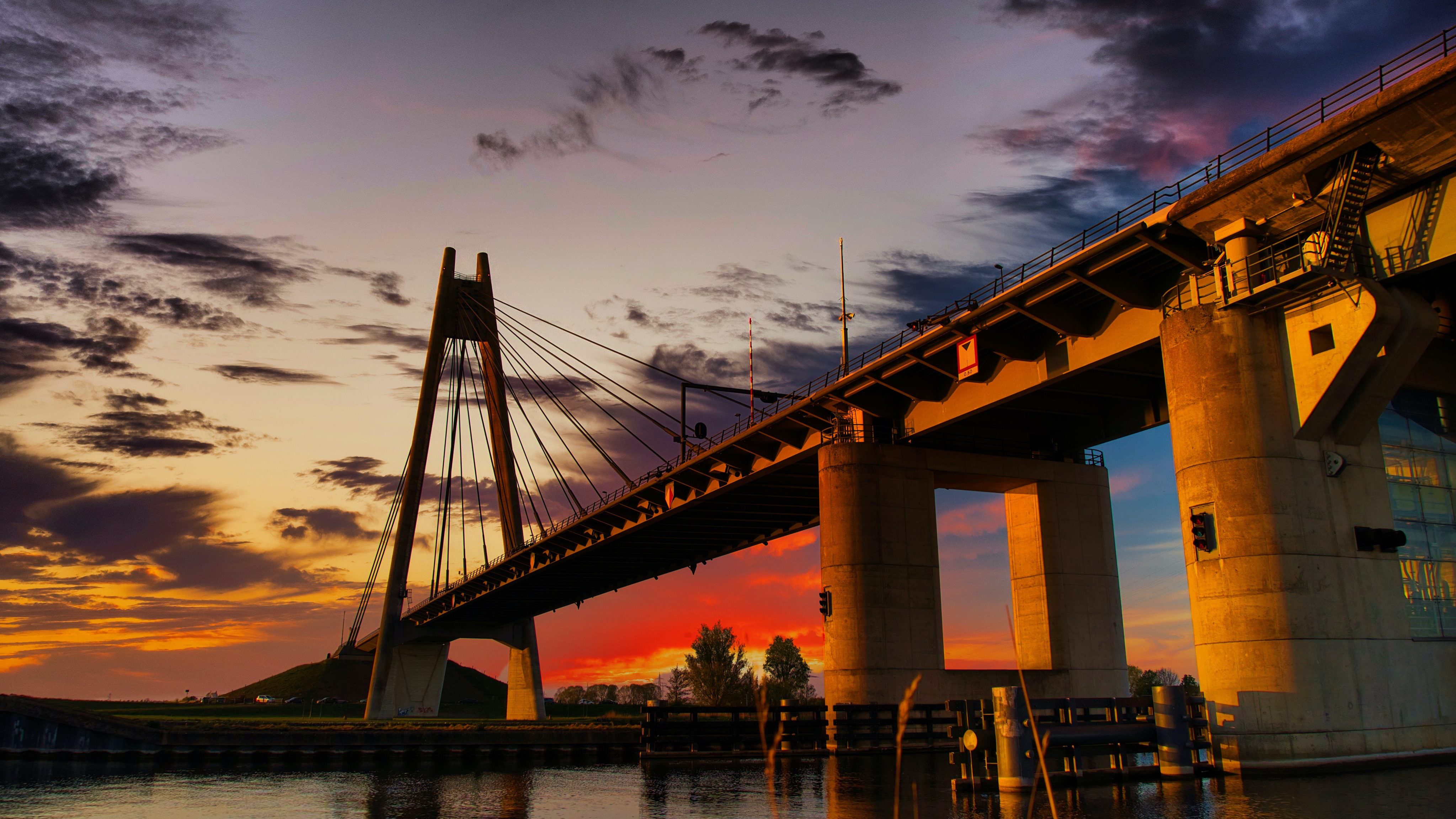 Foto van een brug over de rivier in Apeldoorn bij ondergaande zon