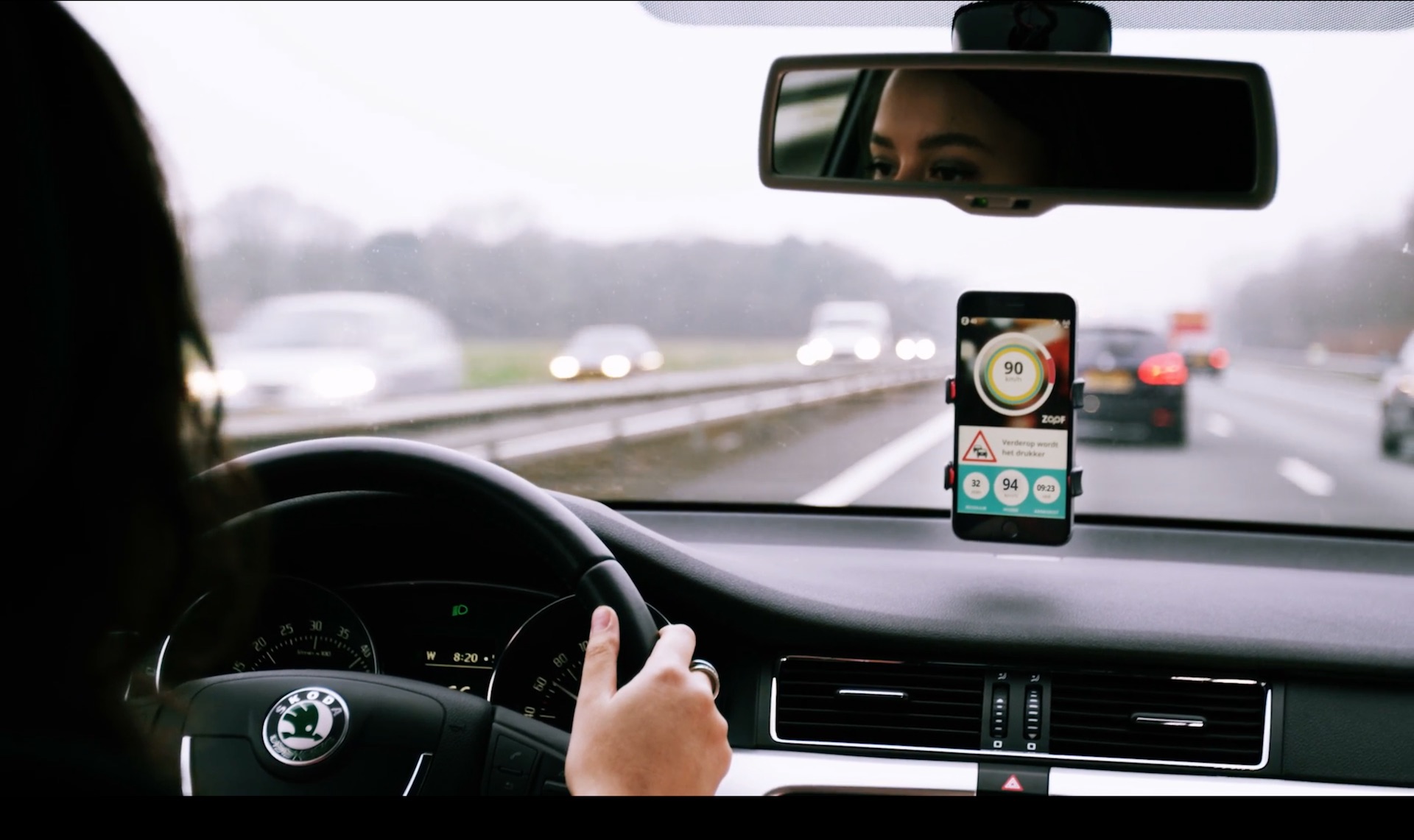 Bestuurder in een auto op de snelweg met navigatie op haar telefoon