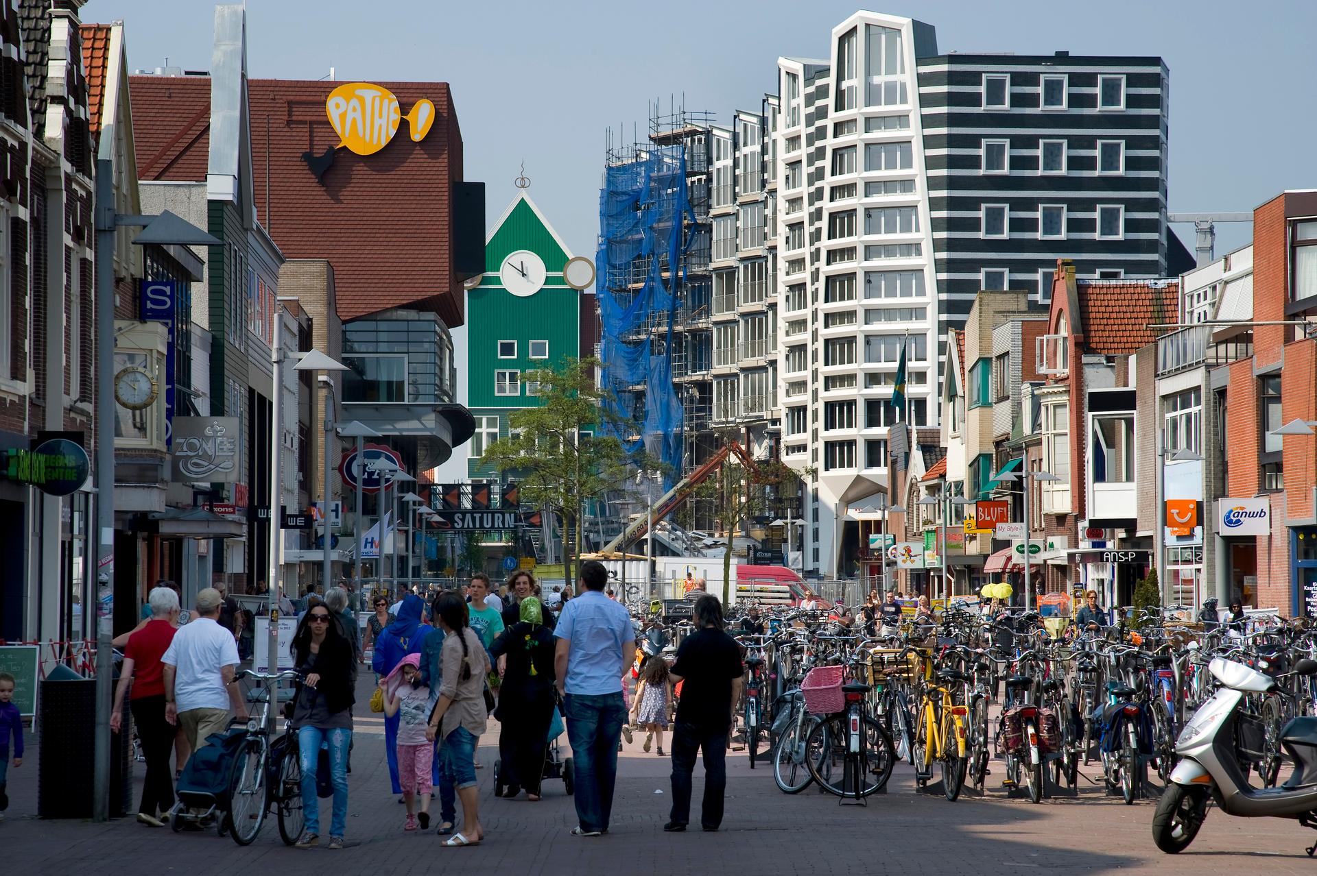 Een binnenstad waar veel mensen lopen en fietsen geparkeerd staan