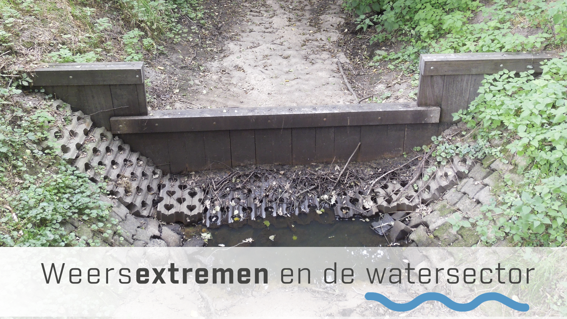 Een dam in de droogvallende Snoeyinksbeek met daaronder de tekst Weersextremen in de watersector