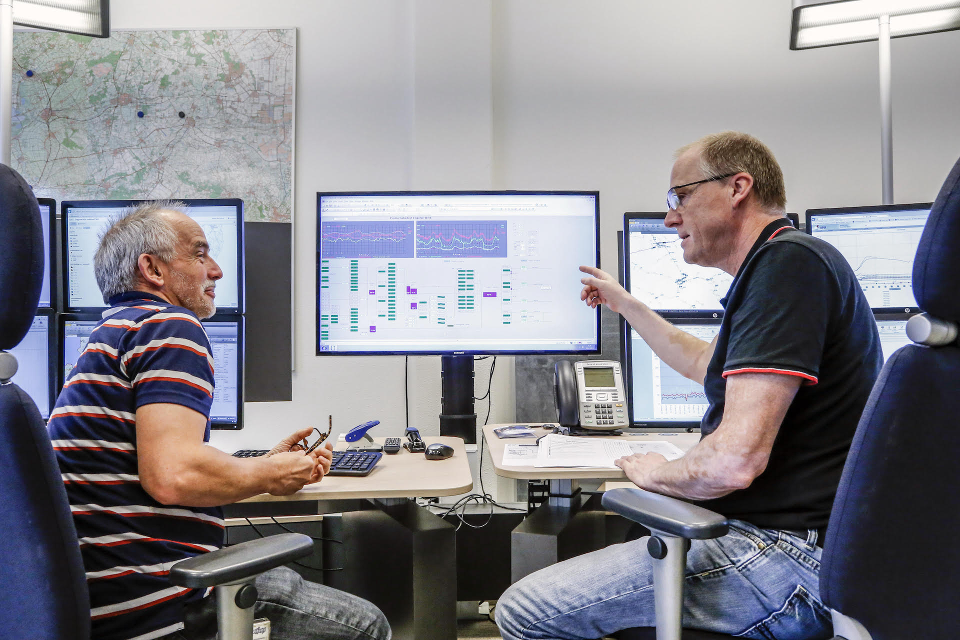 Twee werknemers van Vitens in overleg achter de computer